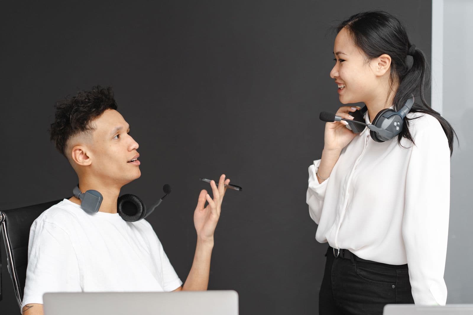 Two team members with headsets discussing a call handoff