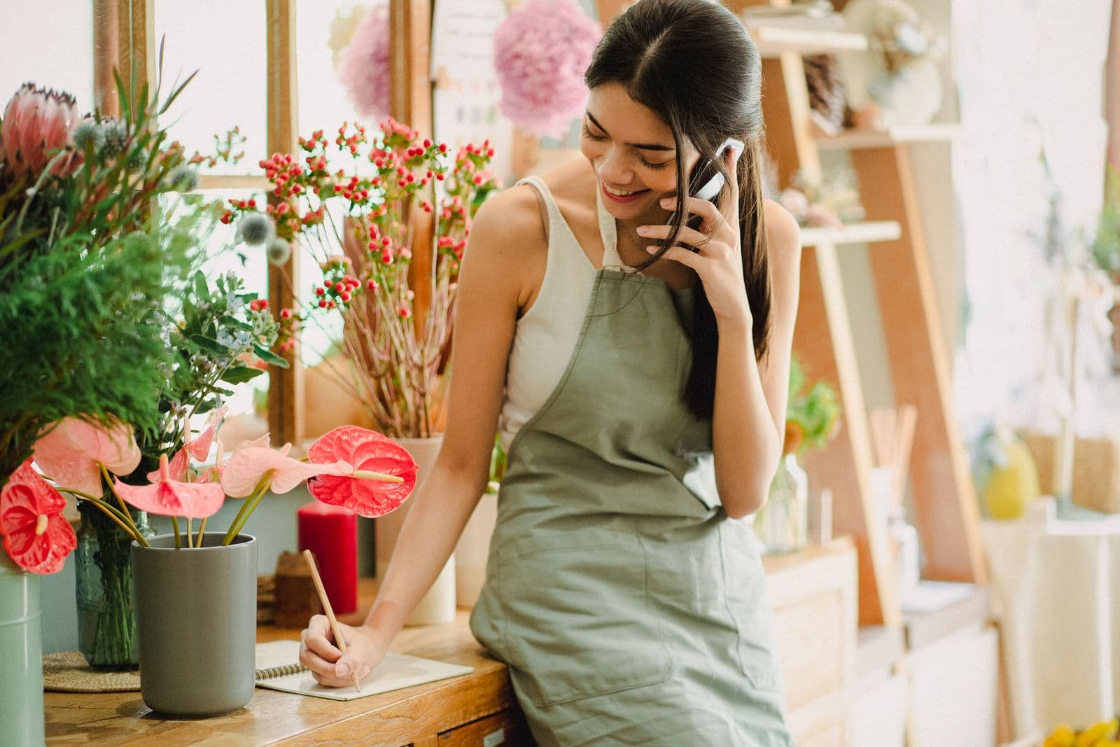 Florist taking a customer order over the phone in her shop