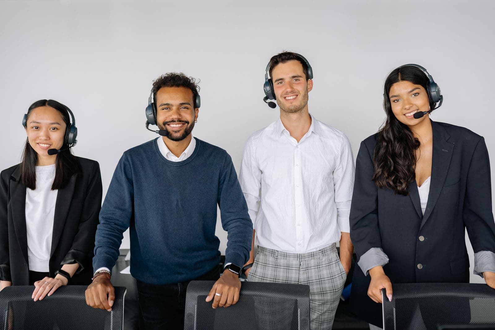 Support team smiling with headsets in a bright office