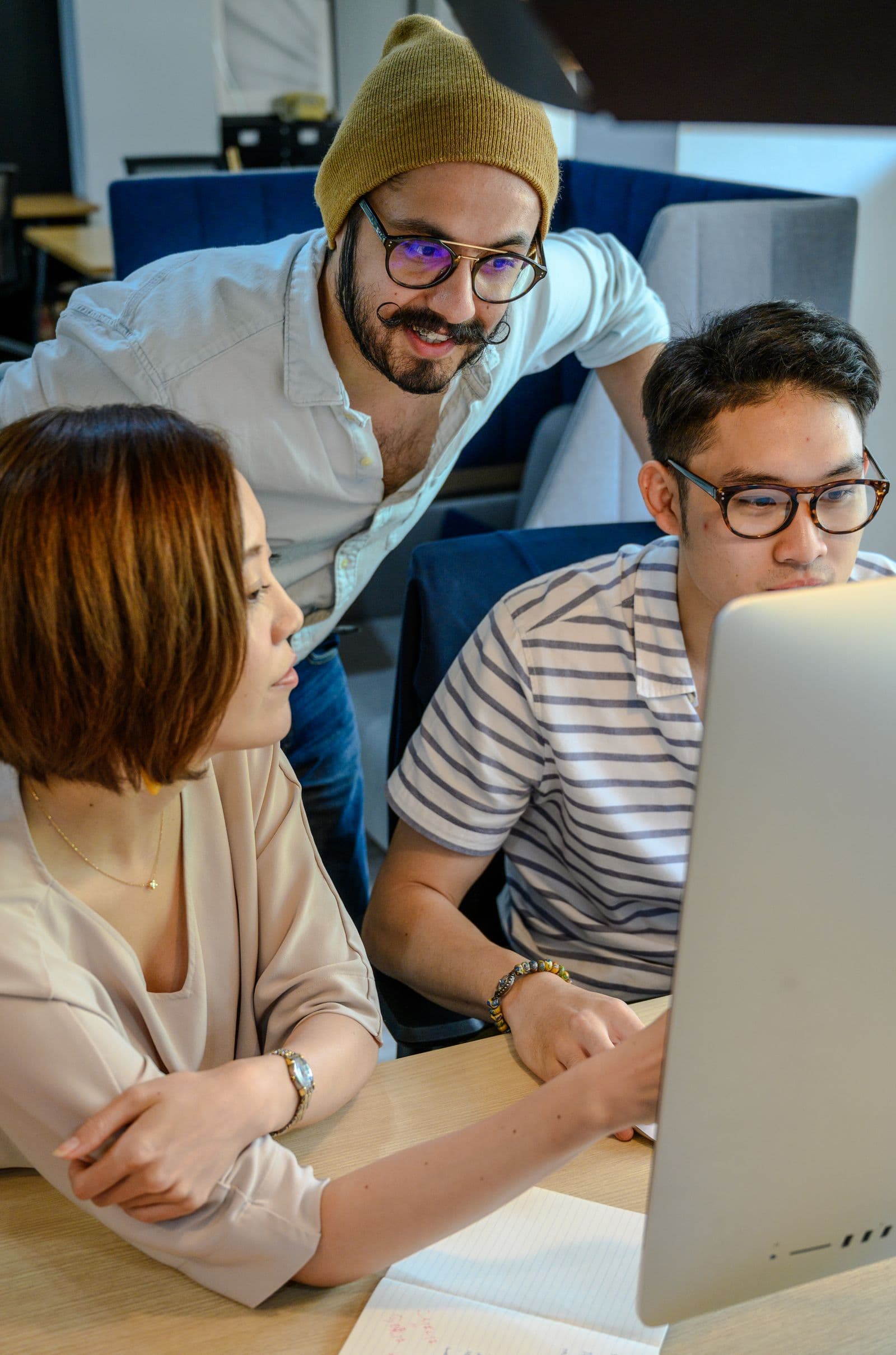 Team collaborating around a computer in a modern office