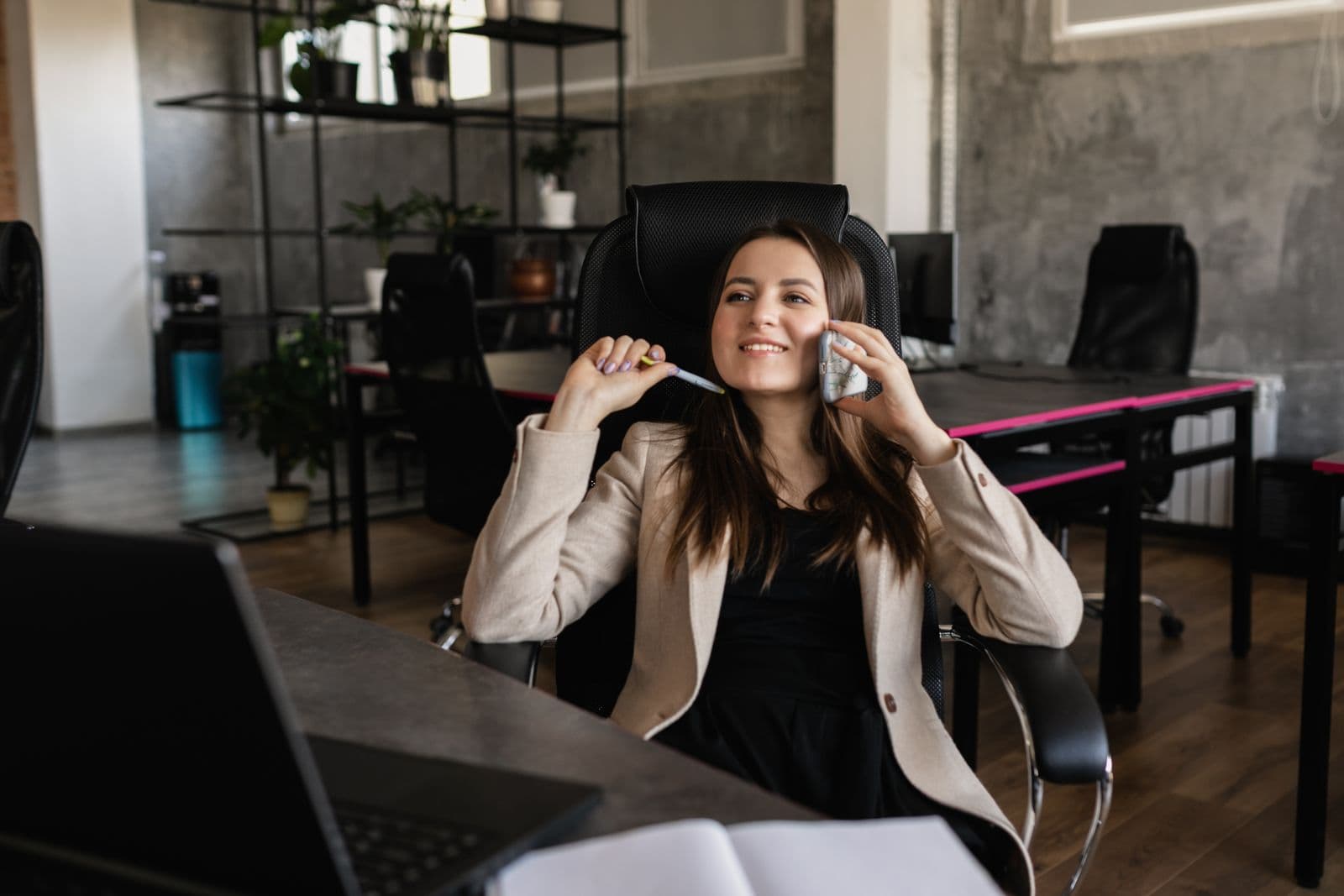 Caller smiling while talking on the phone at a desk