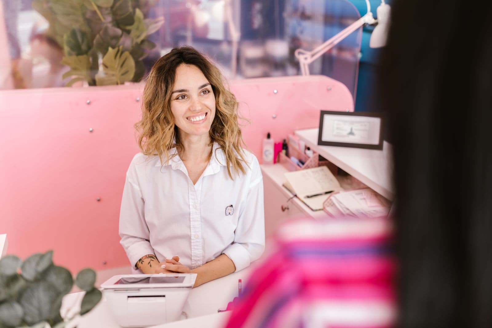 Friendly receptionist welcoming a client at a salon front desk